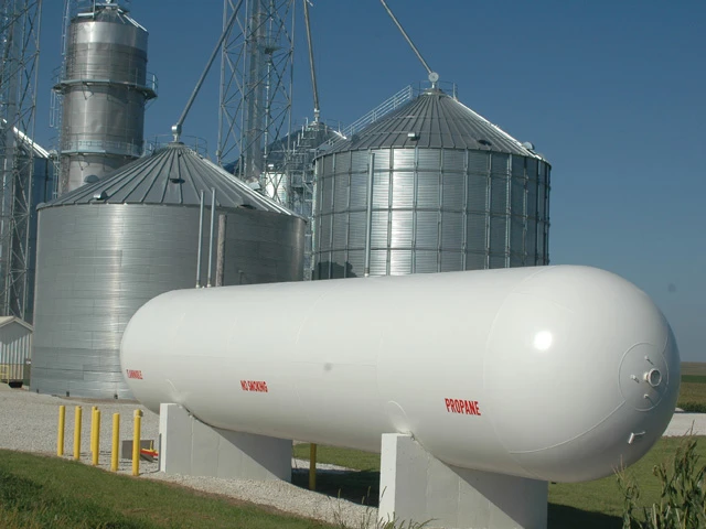 a photo of a propane tank in front of two silver silos