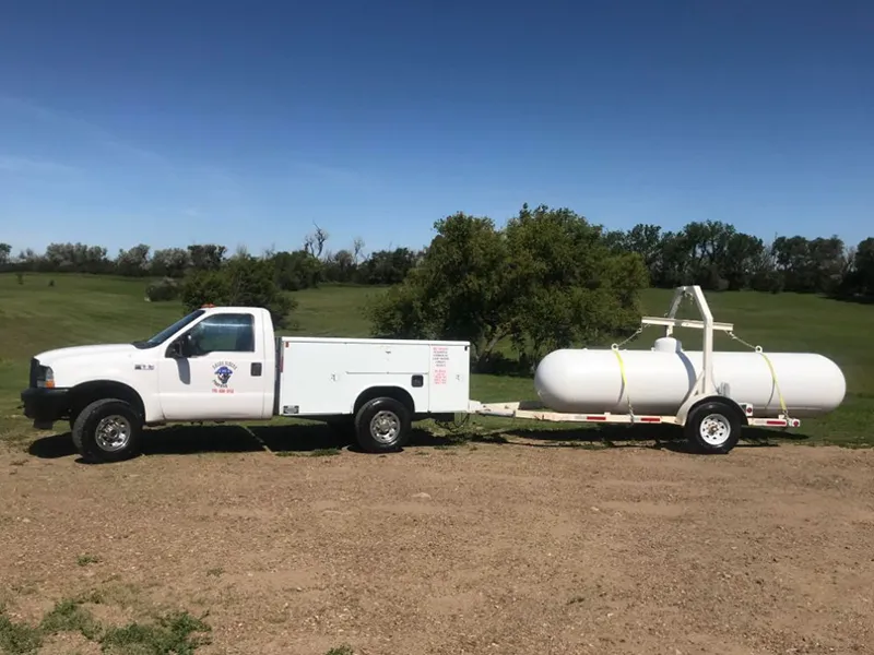 a photo of a ford truck hauling propane on a residential delivery
