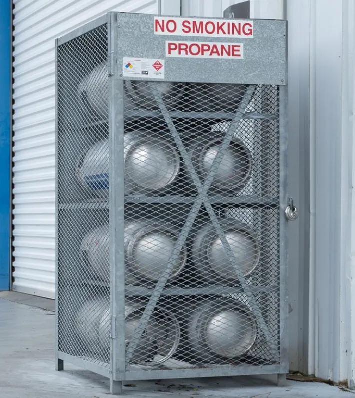 a photo of several propane canisters in a cage outside a commercial building